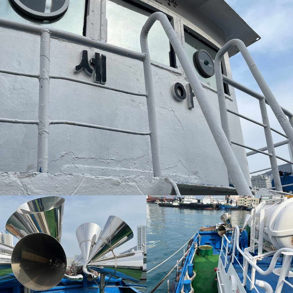 Close-up view of a ship's structure with Korean text and shiny megaphone-like sound horns docked at the port in Yeongdo, Busan.