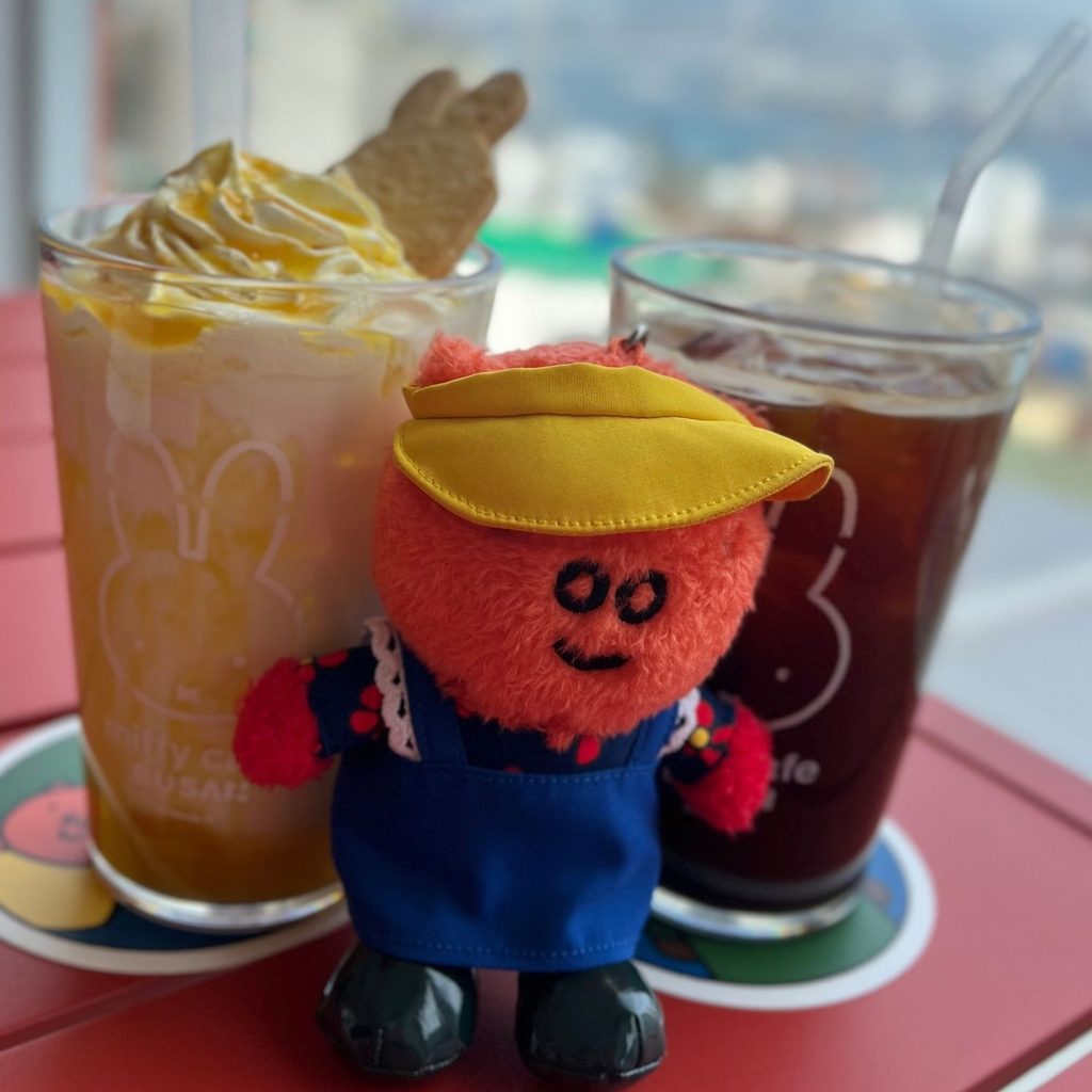 Refreshing beverages and a cute character doll placed on a table at the Miffy Cafe in Yeongdo, Busan.